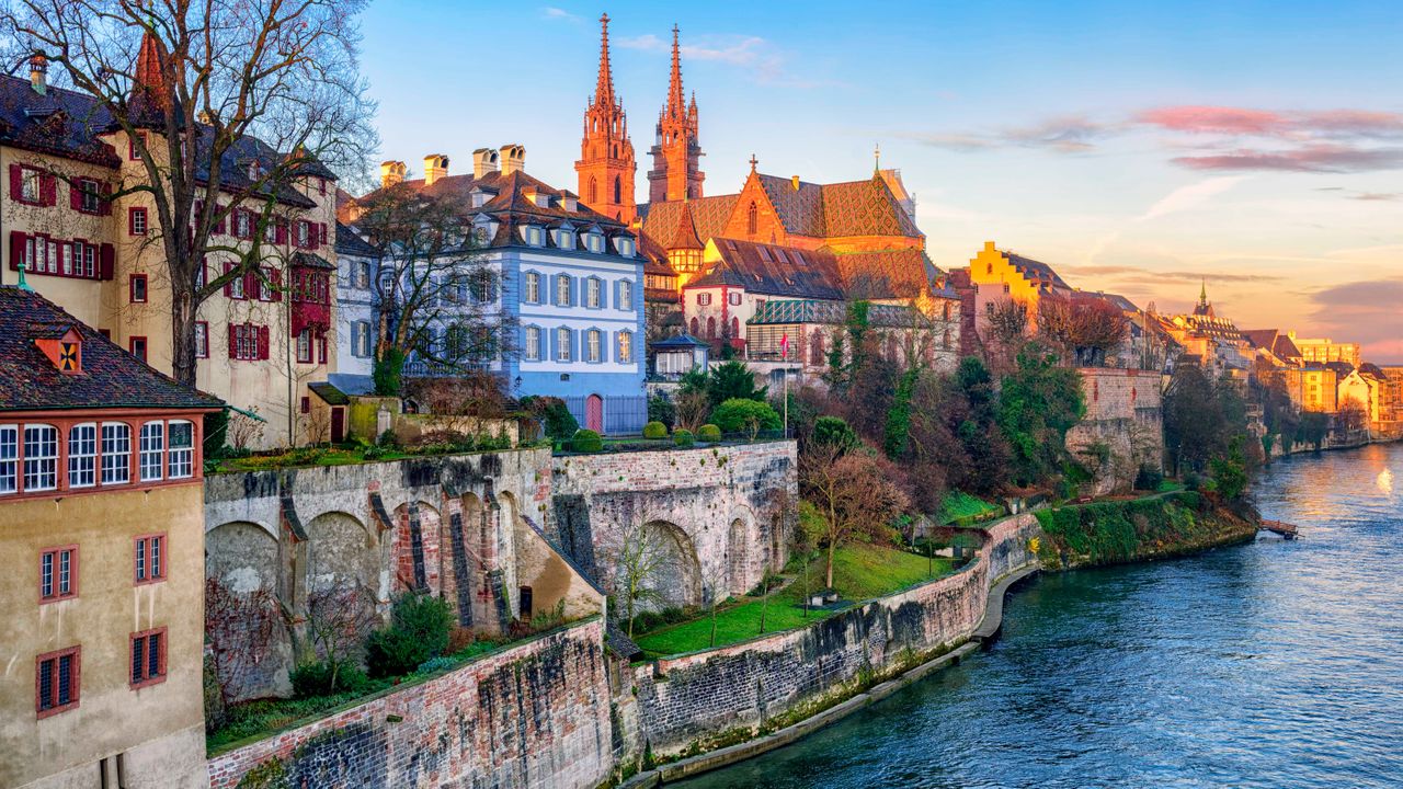 Riverside view of Basel with modern and medieval buildings, listed in the 10 Most Expensive Cities in the world.