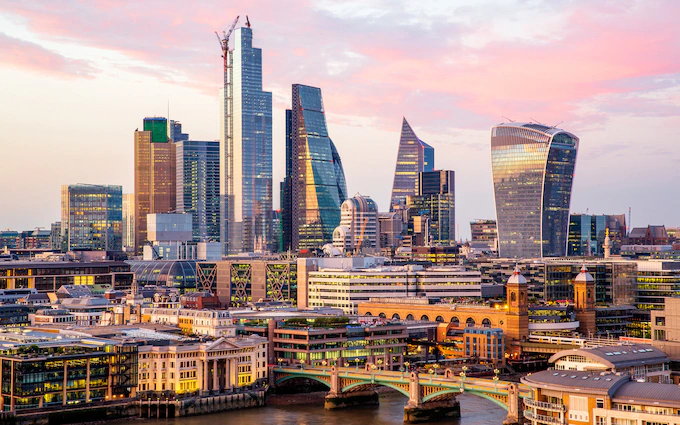 10 Top Cities in the World - London skyline with the city of London, and the River Thames at dusk.