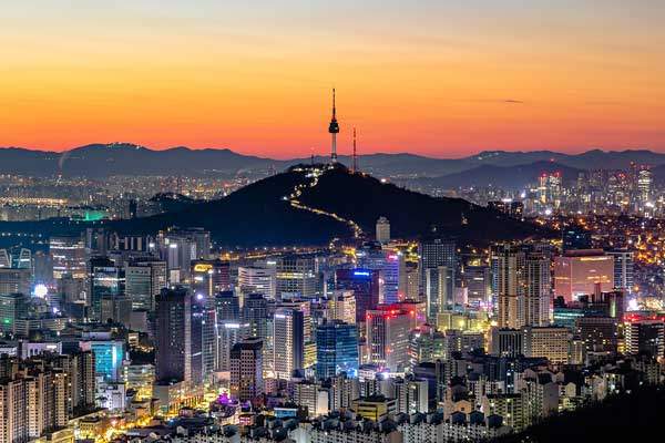 10 Top Cities in the World - Seoul skyline with Namsan Tower and K-pop culture in a high-tech urban setting.