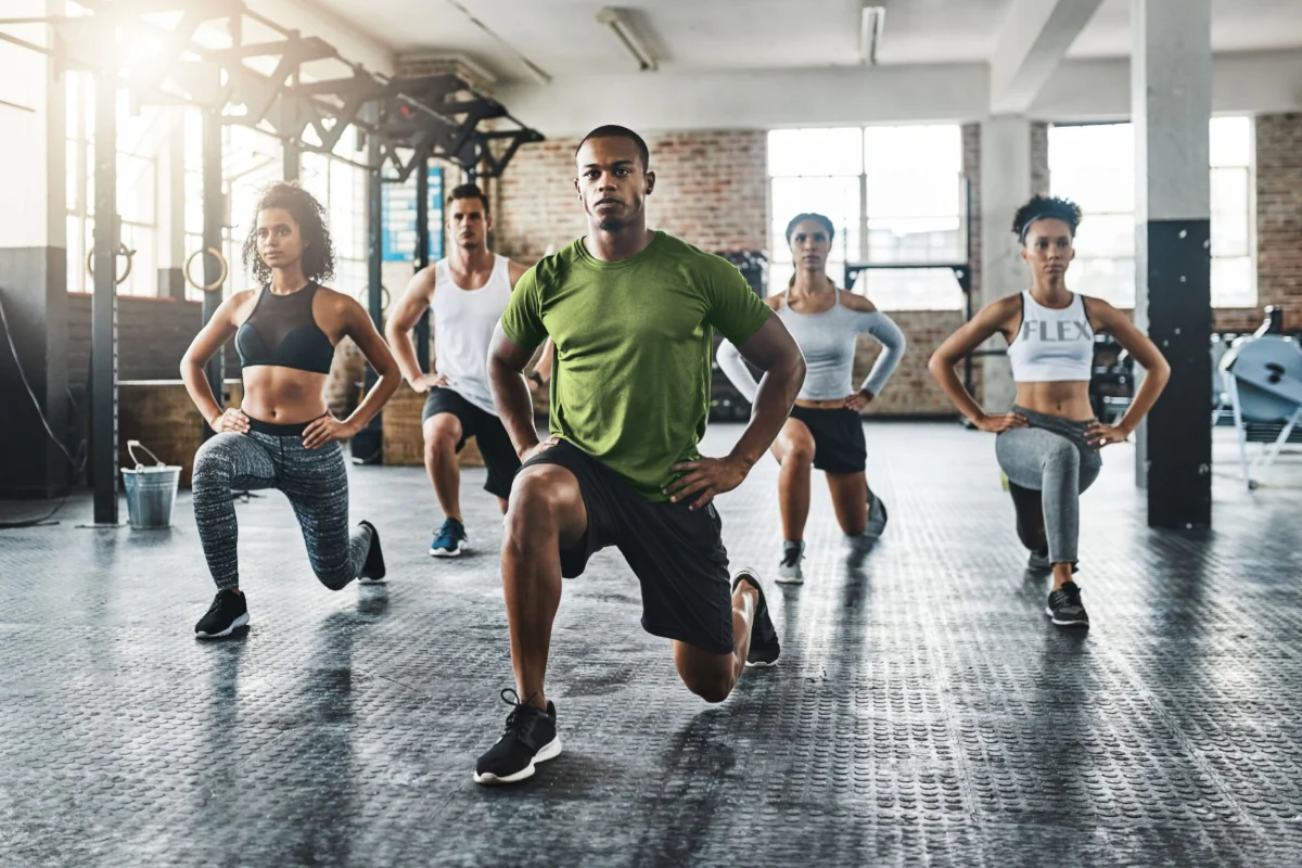 10 Top Fitness Trends in the World - Energetic group workout class in a fitness studio with motivational coach.