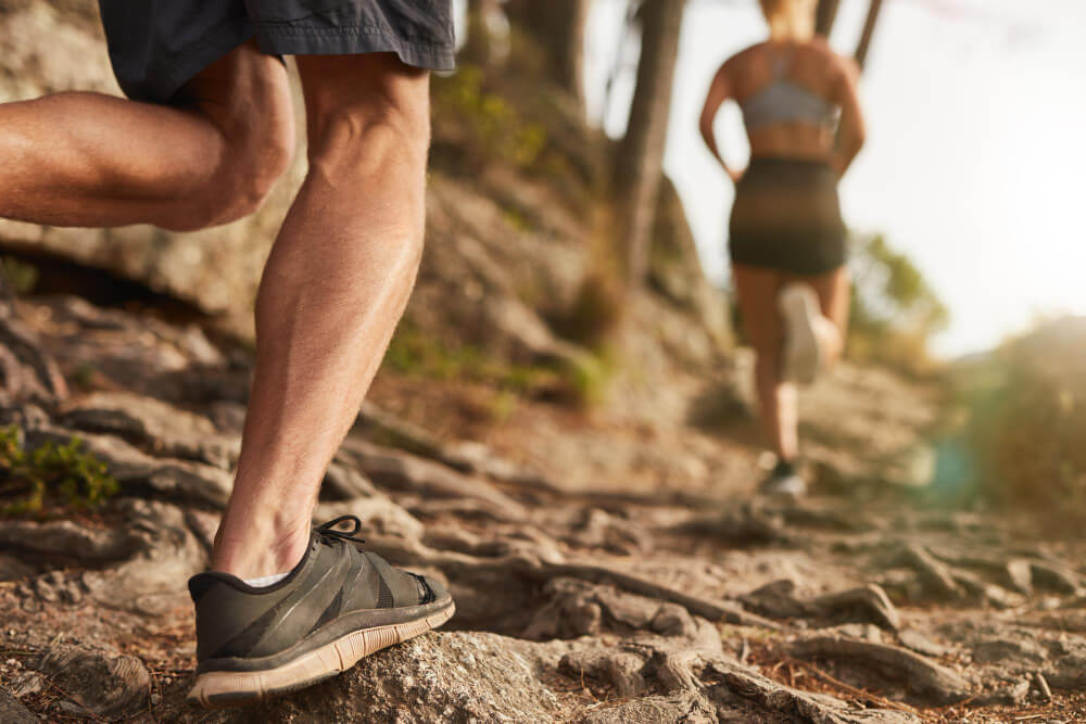 10 Top Fitness Trends in the World - Trail running through nature as part of functional outdoor fitness training.