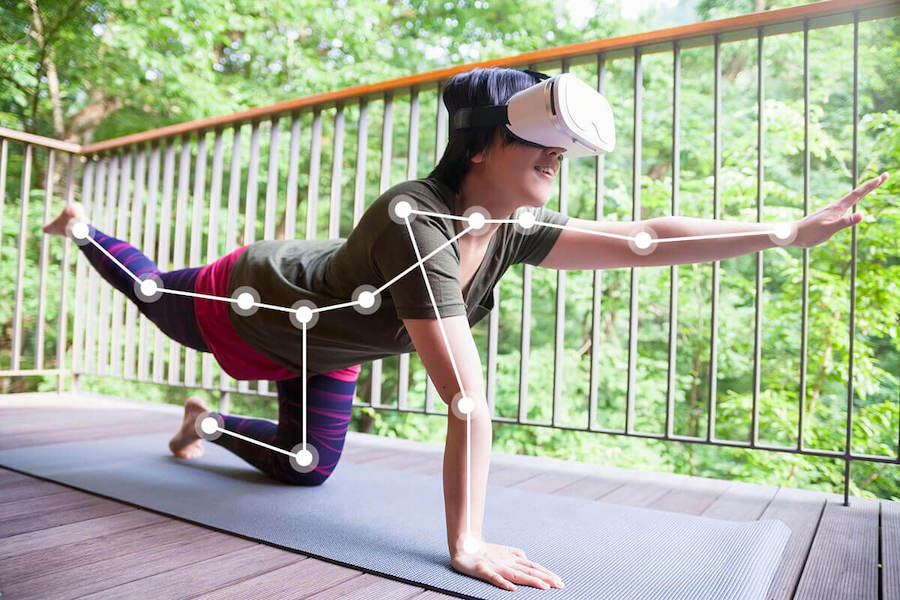 10 Top Fitness Trends in the World - Woman doing a virtual reality fitness game with headset and motion sensors.