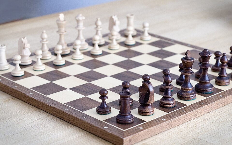 Chess game board representing one of the 10 Most Popular Board Games in the World with players mid-match.