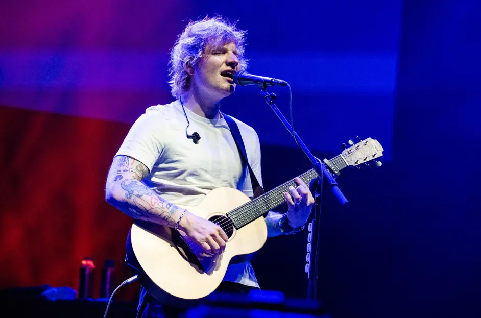 Ed Sheeran playing guitar live, among the 10 Most Famous Musicians in the World blending pop and folk.