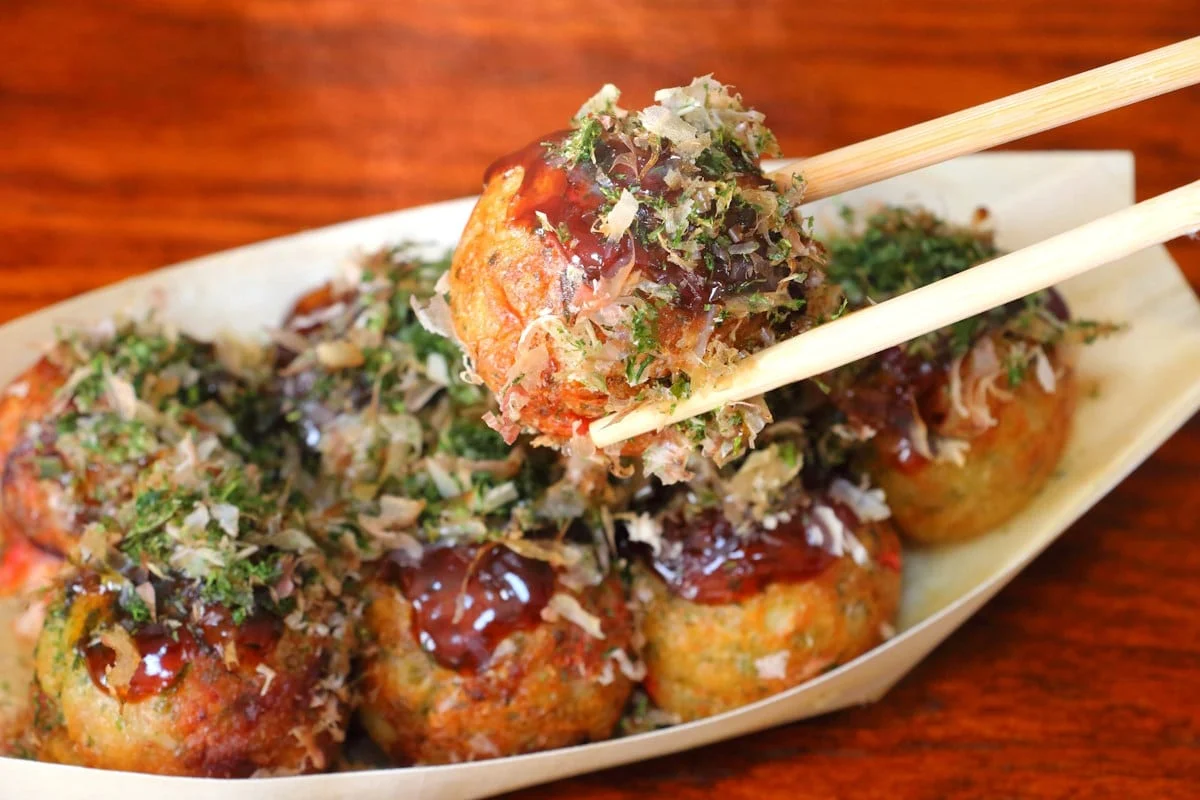 Japanese takoyaki balls serving on a paper plate — featured in the 10 Most Famous Street Foods in the World.
