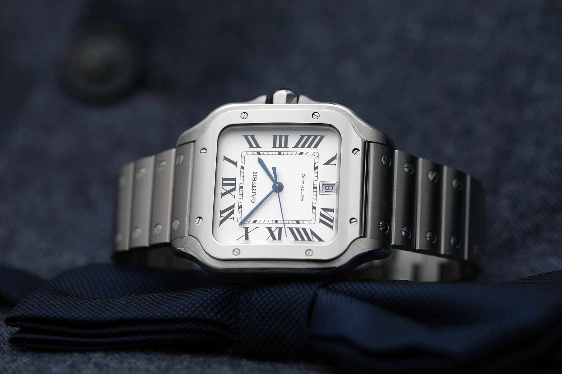 Ultimate Luxury Watch Buying Guide presenting Cartier Santos with steel/gold finish, elegant design, and 100m water resistance.