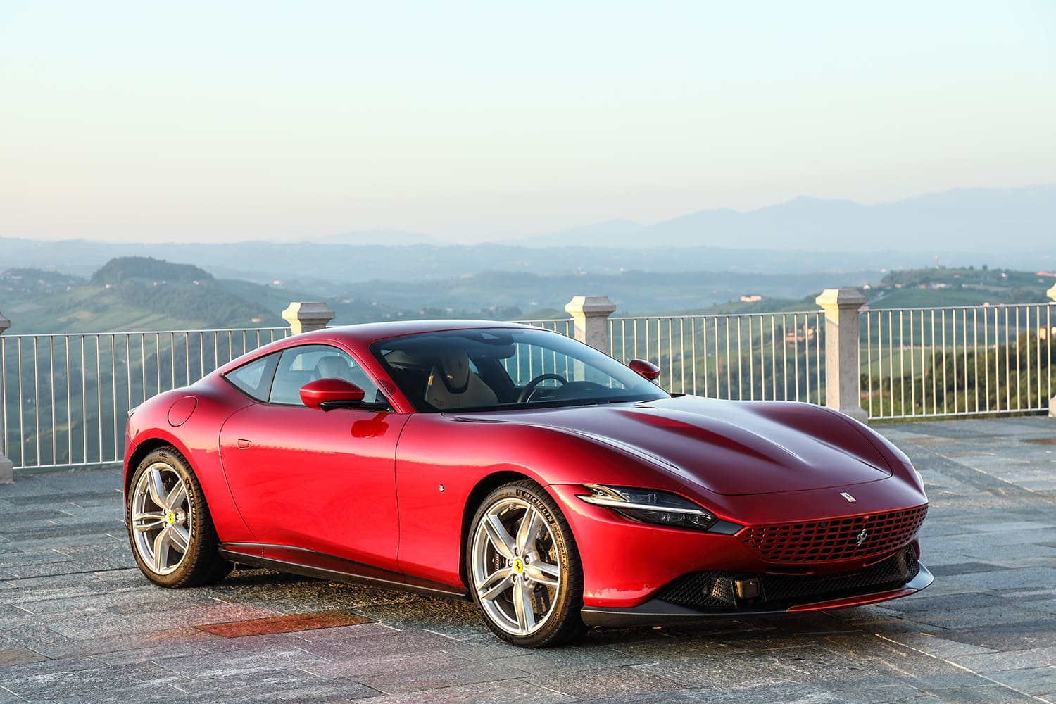 Luxury grand tourer parked on scenic highway – Complete Luxury Supercars Buying Guide highlighting GT elegance and performance.